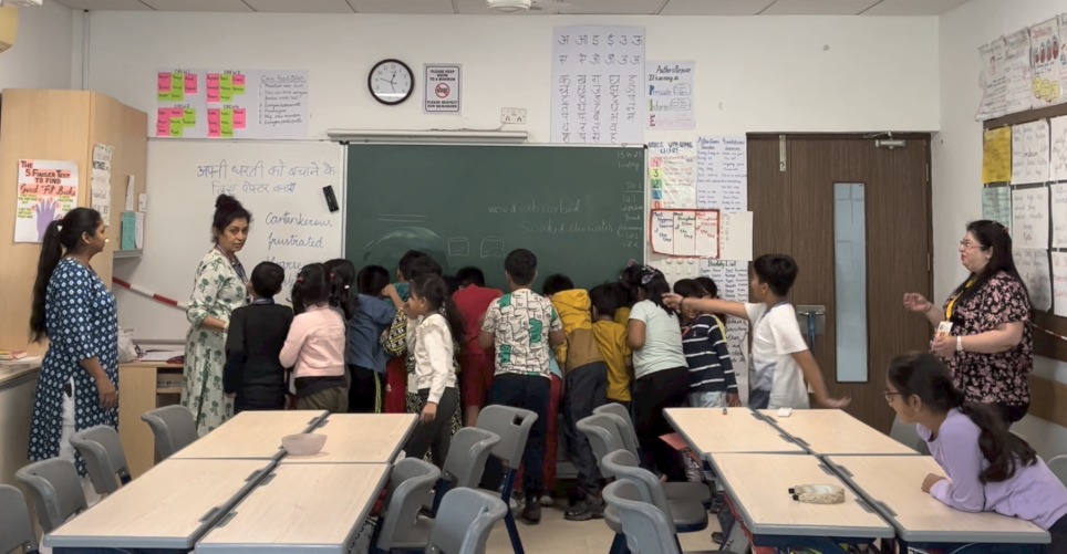 Children working around their teacher with books open