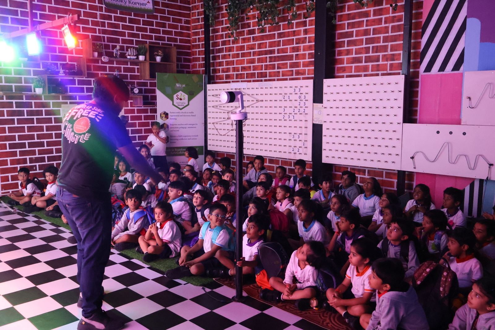 A Madlabs facilitator holding the attention of a seated audience of children