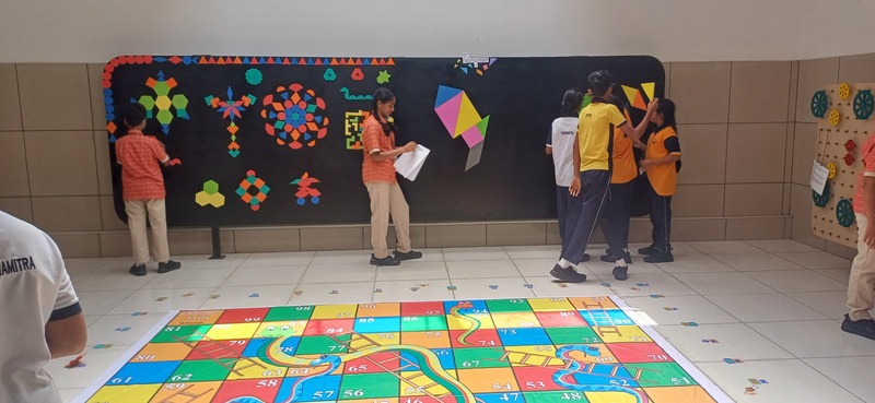 Children playing a life-sized maths floor game in a school corridor
