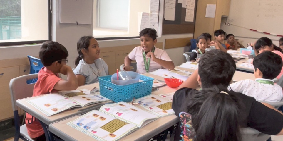 Children working in their workbooks at their desks